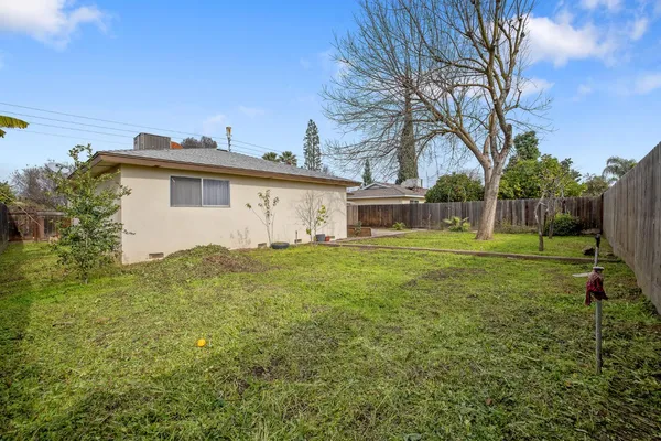 a view of a house with backyard and trees