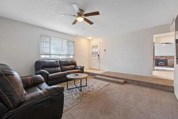 a living room with furniture a ceiling fan and a window