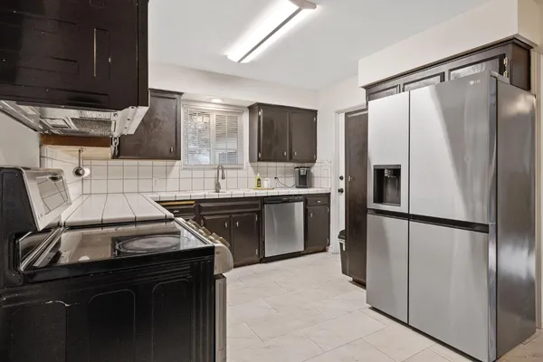 a kitchen with stainless steel appliances granite countertop a stove microwave and sink