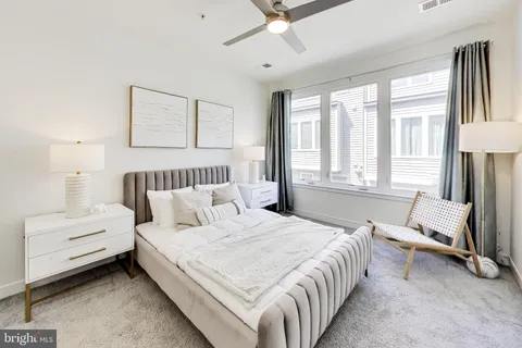 a bedroom with a bed and a large window