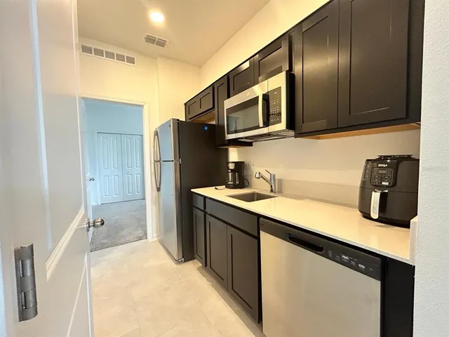 a kitchen with stainless steel appliances a sink cabinets and microwave