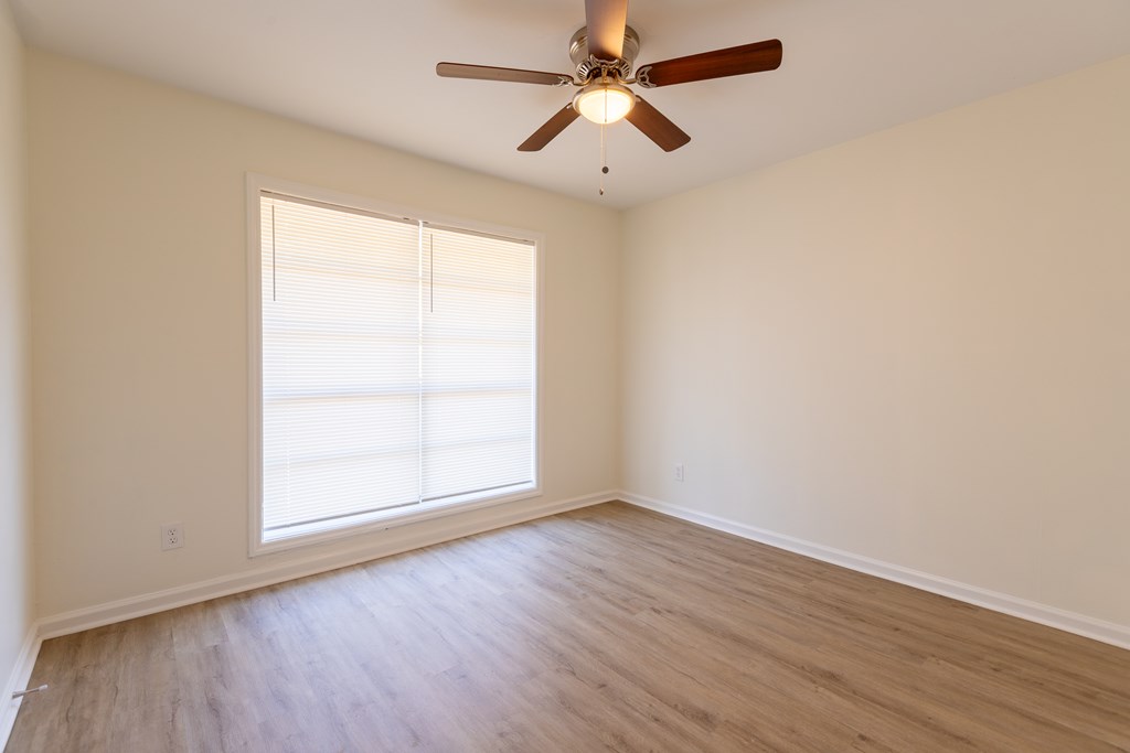 4813 Rowland Court Columbus, GA 31907 - Photo 7 of 16 an empty room with wooden floor ceiling fan and windows