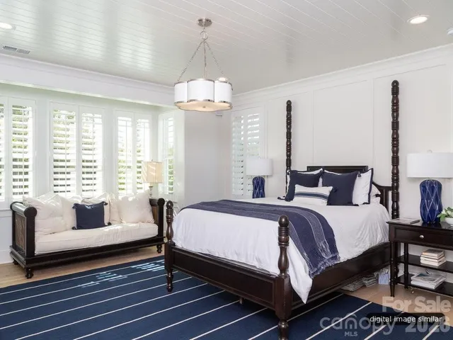 a spacious bedroom with a bed and a chandelier