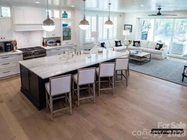 a kitchen with a dining table chairs and white cabinets
