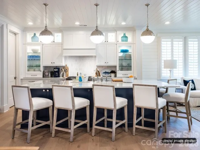 a kitchen with a dining table chairs sink and wooden floor