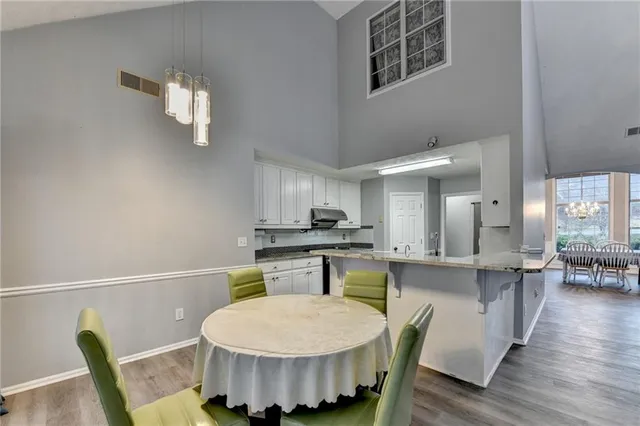 a kitchen with a sink a stove and chairs