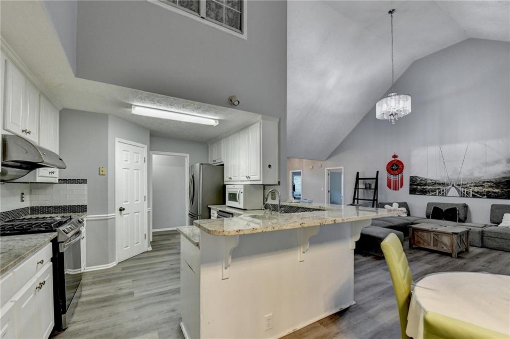 235 Ruby Forest Parkway Suwanee, GA 30024 - Photo 22 of 59 a kitchen with a sink a stove and chairs