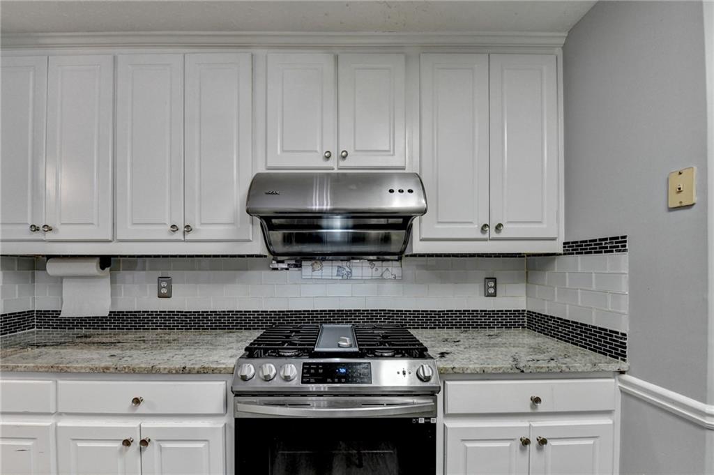 235 Ruby Forest Parkway Suwanee, GA 30024 - Photo 27 of 59 a kitchen with granite countertop white cabinets and stainless steel appliances