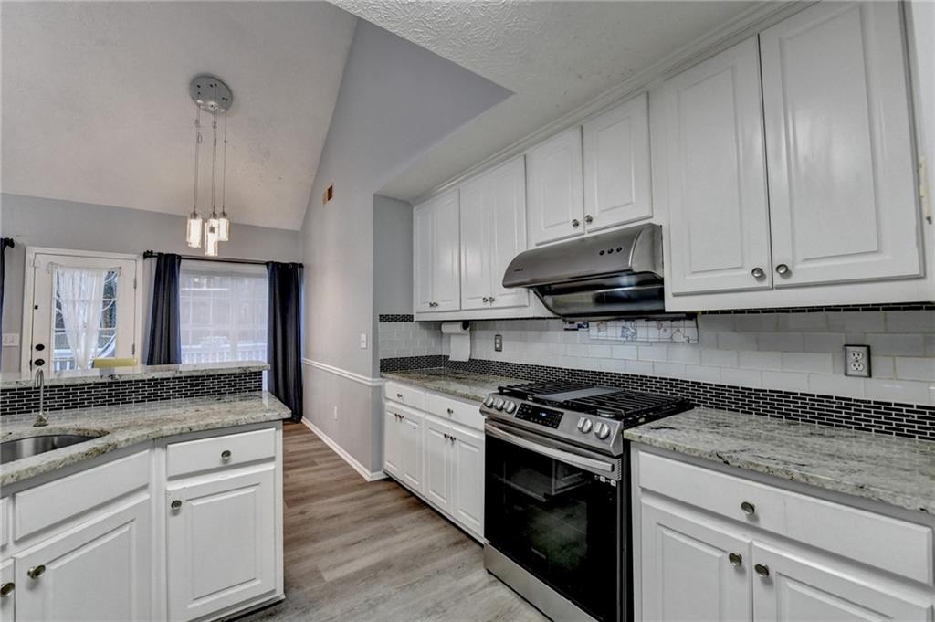 235 Ruby Forest Parkway Suwanee, GA 30024 - Photo 29 of 59 a kitchen with granite countertop a sink stainless steel appliances and cabinets