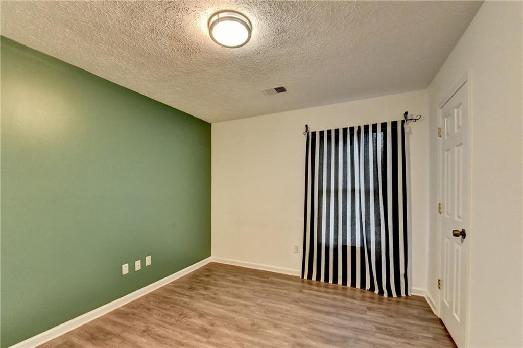 235 Ruby Forest Parkway Suwanee, GA 30024 - Photo 31 of 59 an empty room with wooden floor and windows