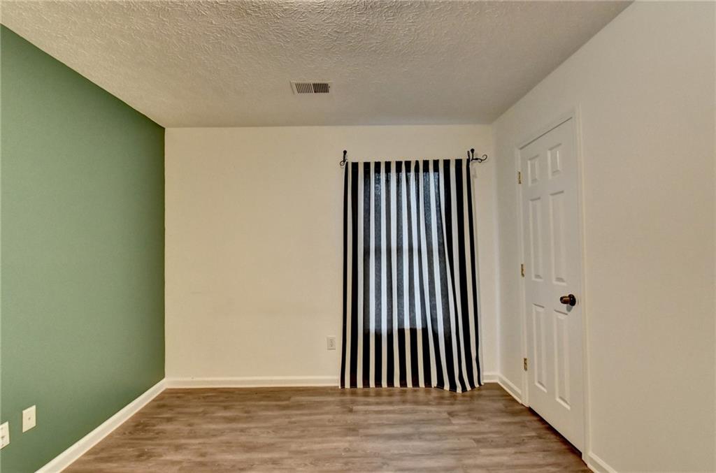 235 Ruby Forest Parkway Suwanee, GA 30024 - Photo 32 of 59 an empty room with wooden floor and windows