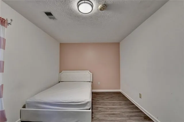 a spacious bedroom with a large bed and a chandelier