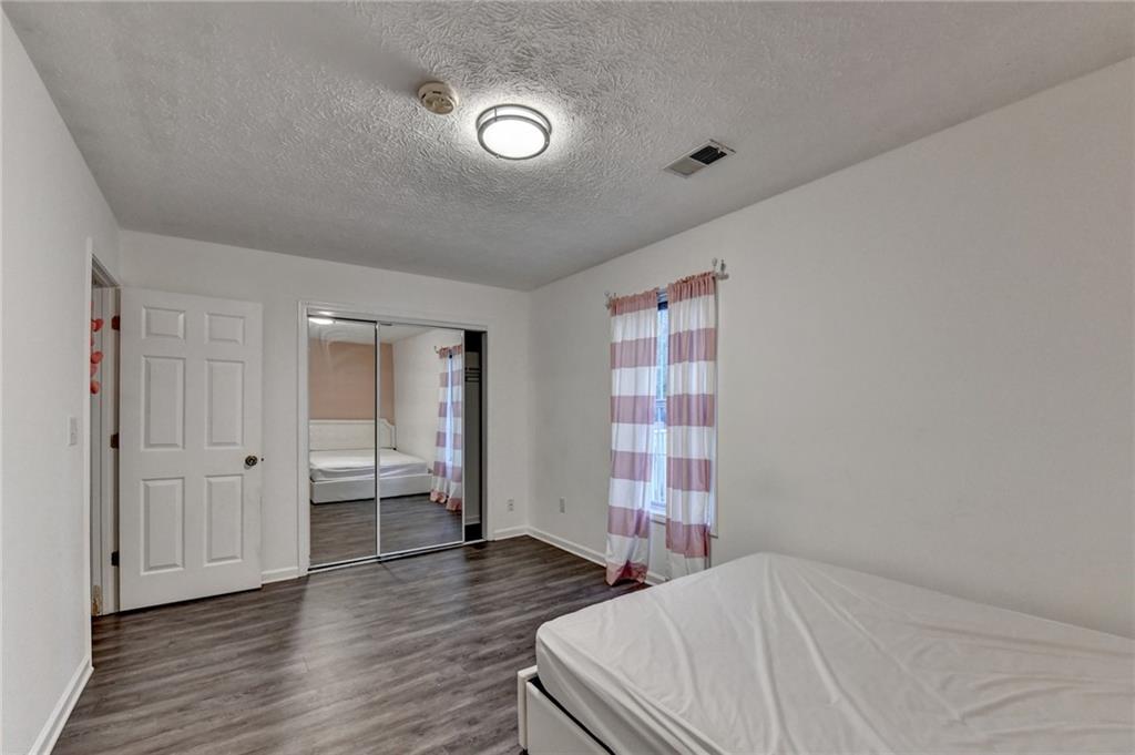 235 Ruby Forest Parkway Suwanee, GA 30024 - Photo 38 of 59 a bedroom with a bed and wooden floor