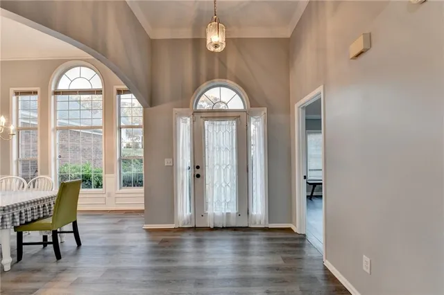 a view of a dining room with furniture a chandelier and wooden floor