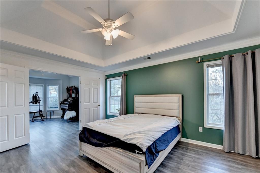 235 Ruby Forest Parkway Suwanee, GA 30024 - Photo 42 of 59 a spacious bedroom with a large bed and a chandelier