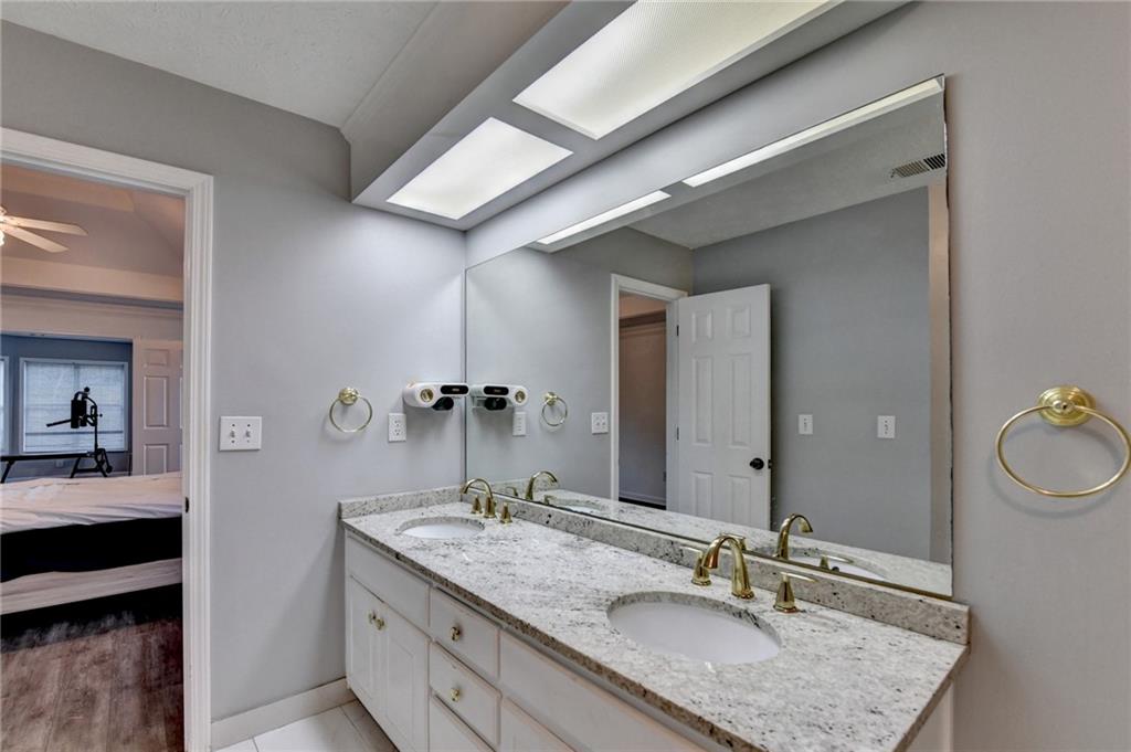 235 Ruby Forest Parkway Suwanee, GA 30024 - Photo 50 of 59 a bathroom with a granite countertop sink a mirror and vanity