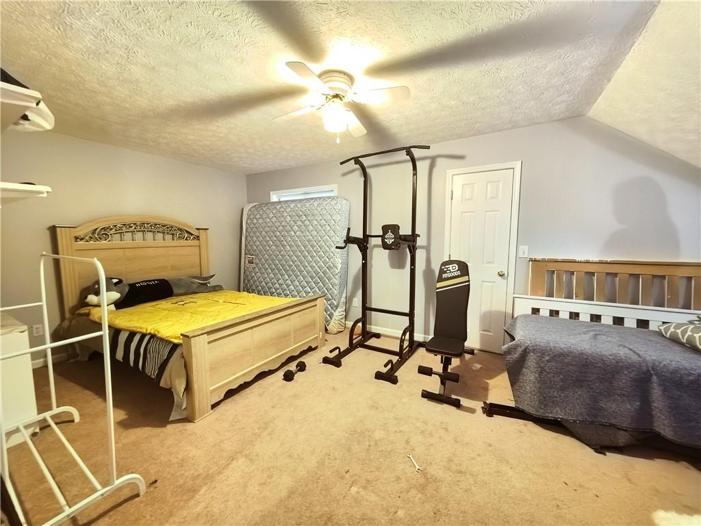 235 Ruby Forest Parkway Suwanee, GA 30024 - Photo 52 of 59 a bedroom with a bed and gym equipment
