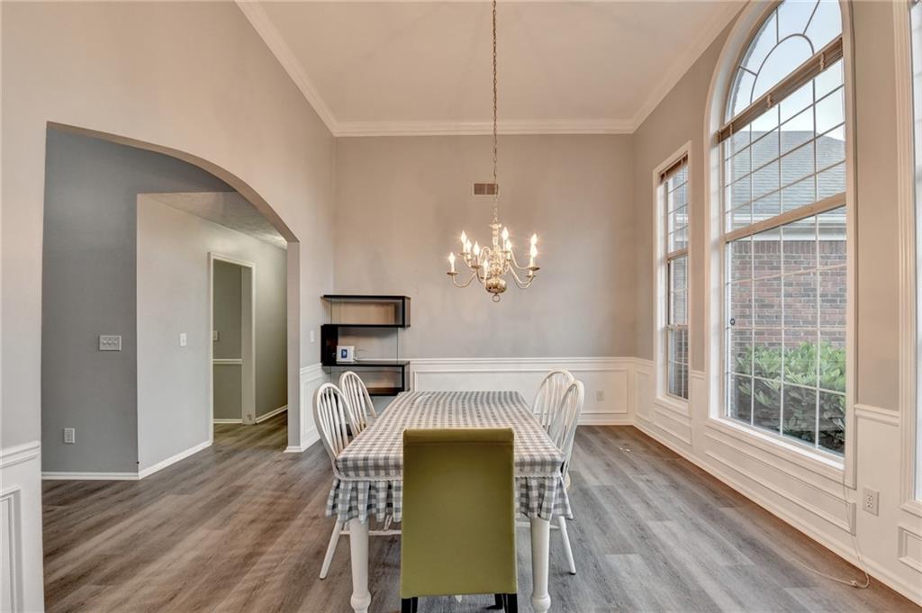 235 Ruby Forest Parkway Suwanee, GA 30024 - Photo 6 of 59 a view of a dining room with furniture a chandelier and wooden floor