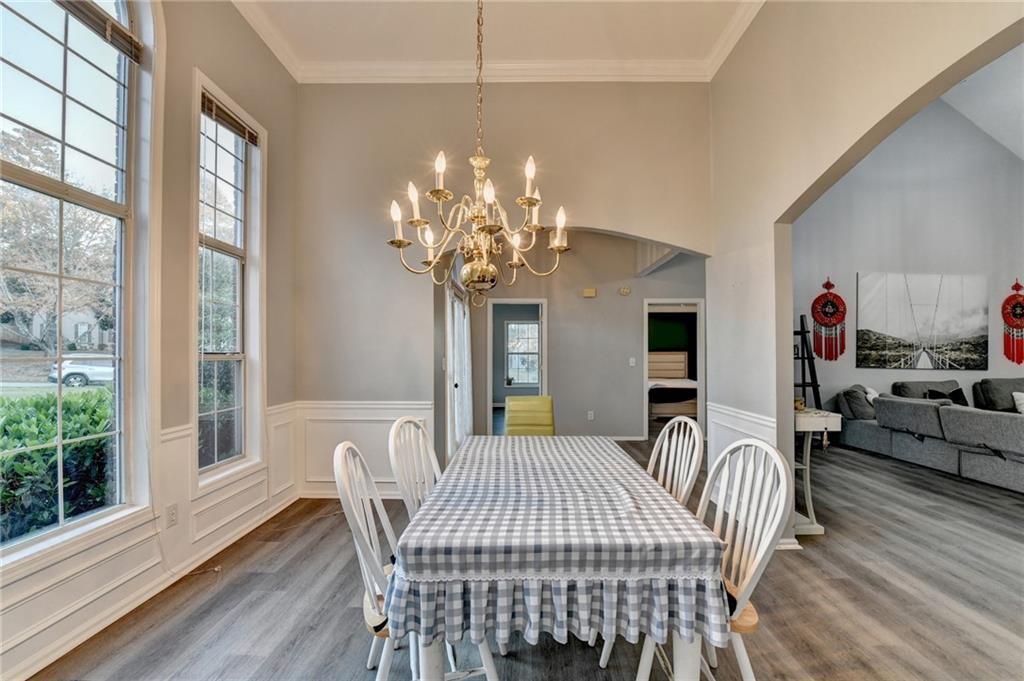 235 Ruby Forest Parkway Suwanee, GA 30024 - Photo 9 of 59 a view of a dining room with furniture a chandelier and wooden floor