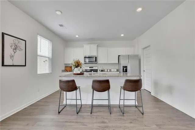 a kitchen with cabinets and chairs in it