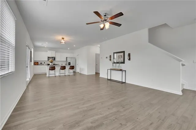 a view of a livingroom with furniture a ceiling fan and wooden floor