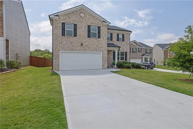 a front view of a house with a yard and garage