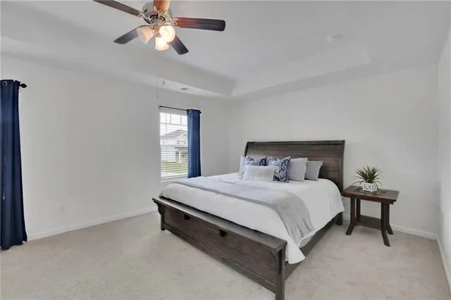 a spacious bedroom with a bed and a chandelier