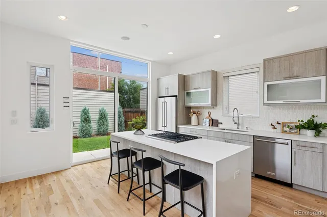 a kitchen with stainless steel appliances a table and chairs in it