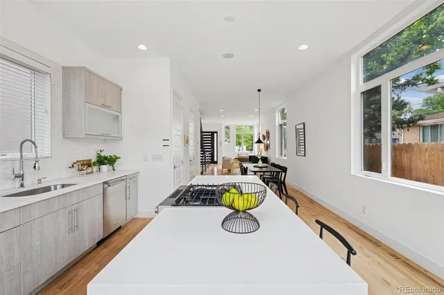 a kitchen with a sink a counter top space and living room area