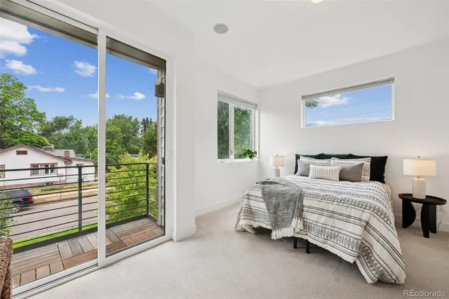 a bedroom with a bed and a balcony view