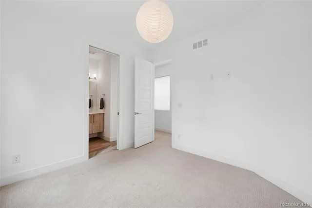 a view of an empty room with wooden floor and a flat screen tv