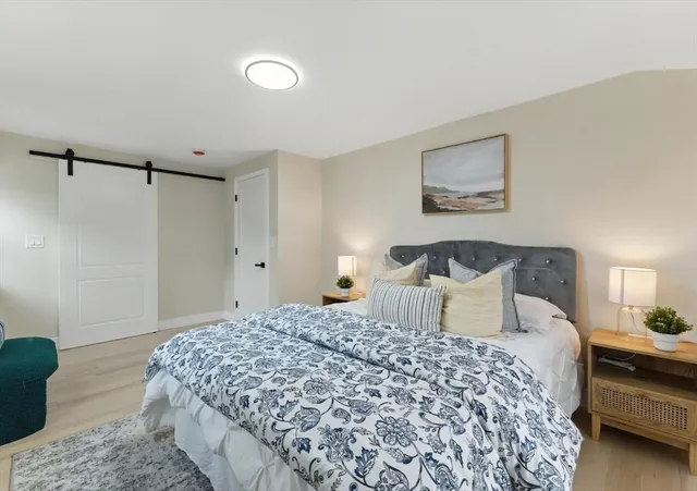 a bedroom with a bed and a painting on the wall