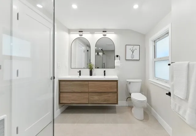 a bathroom with a toilet sink and mirror