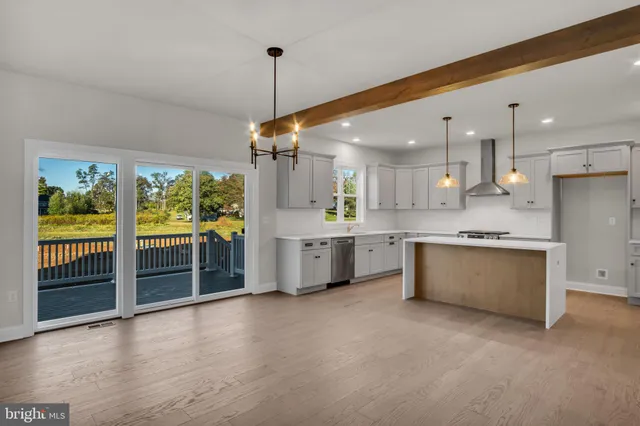 a large kitchen with a large window a sink and stainless steel appliances
