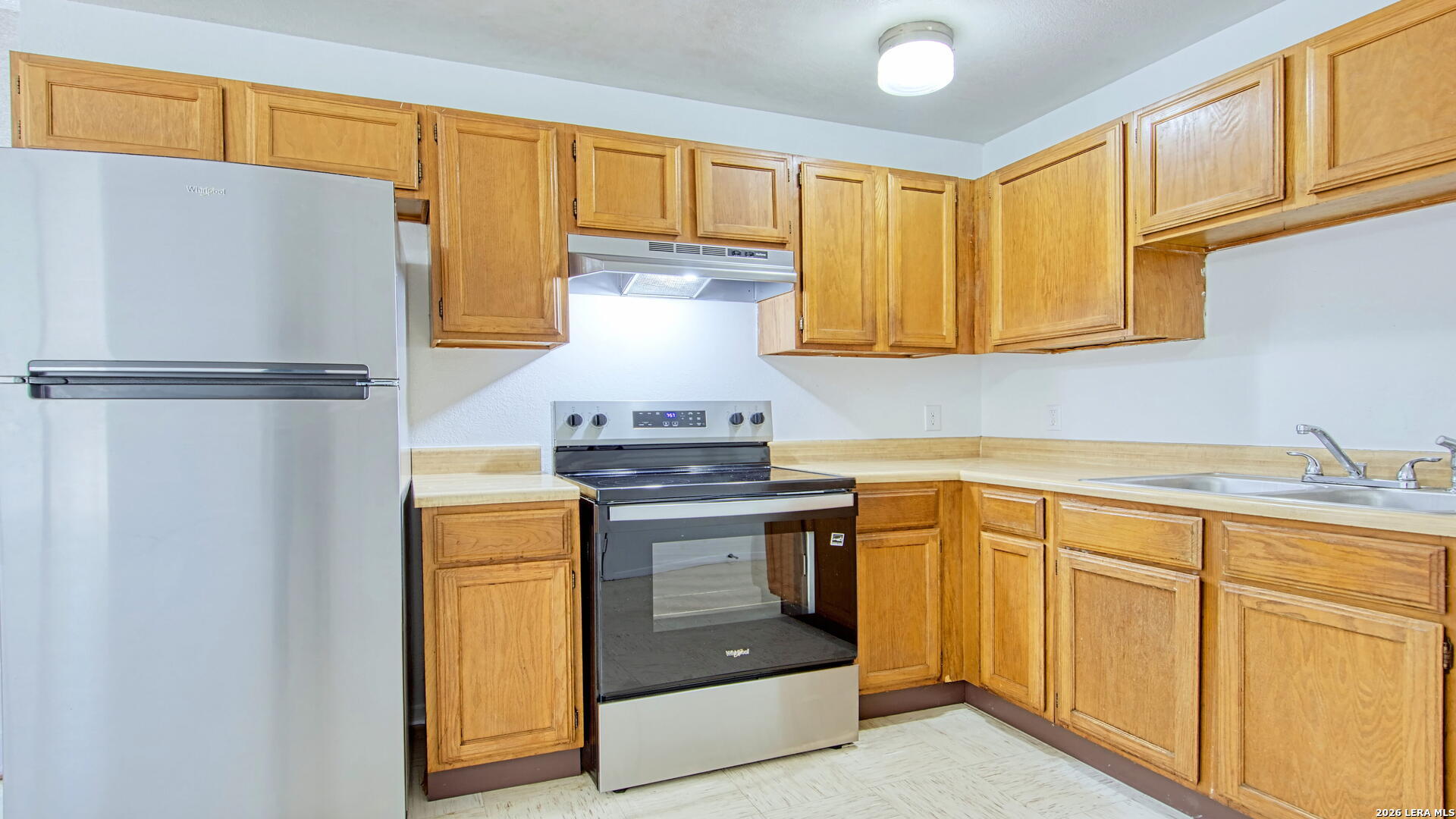 406 Pine Street Kenedy, TX 78119 - Photo 2 of 31 a kitchen with stainless steel appliances a stove a refrigerator and cabinets