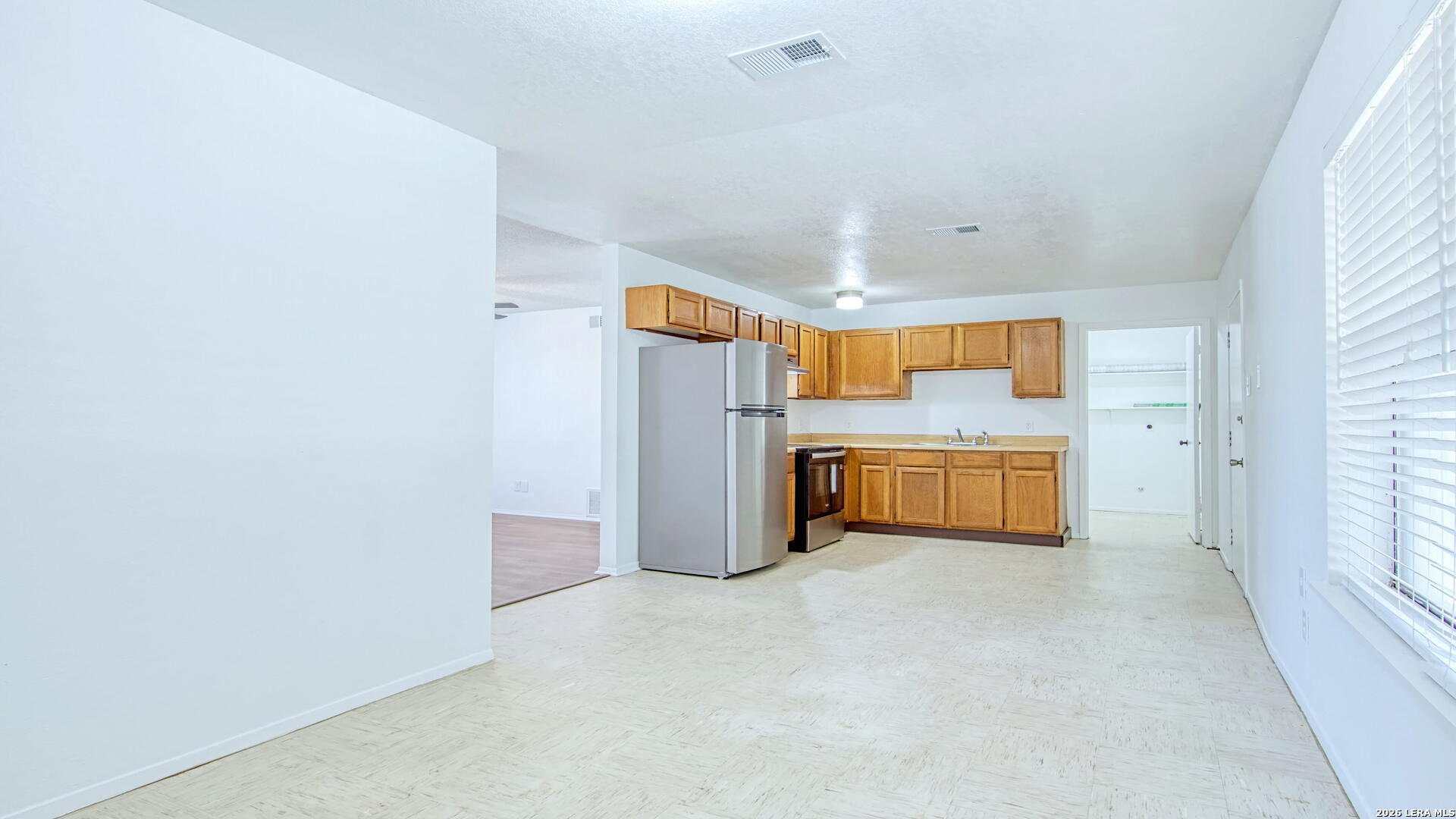 406 Pine Street Kenedy, TX 78119 - Photo 21 of 31 a view of a kitchen with a sink and dishwasher a refrigerator with white cabinets