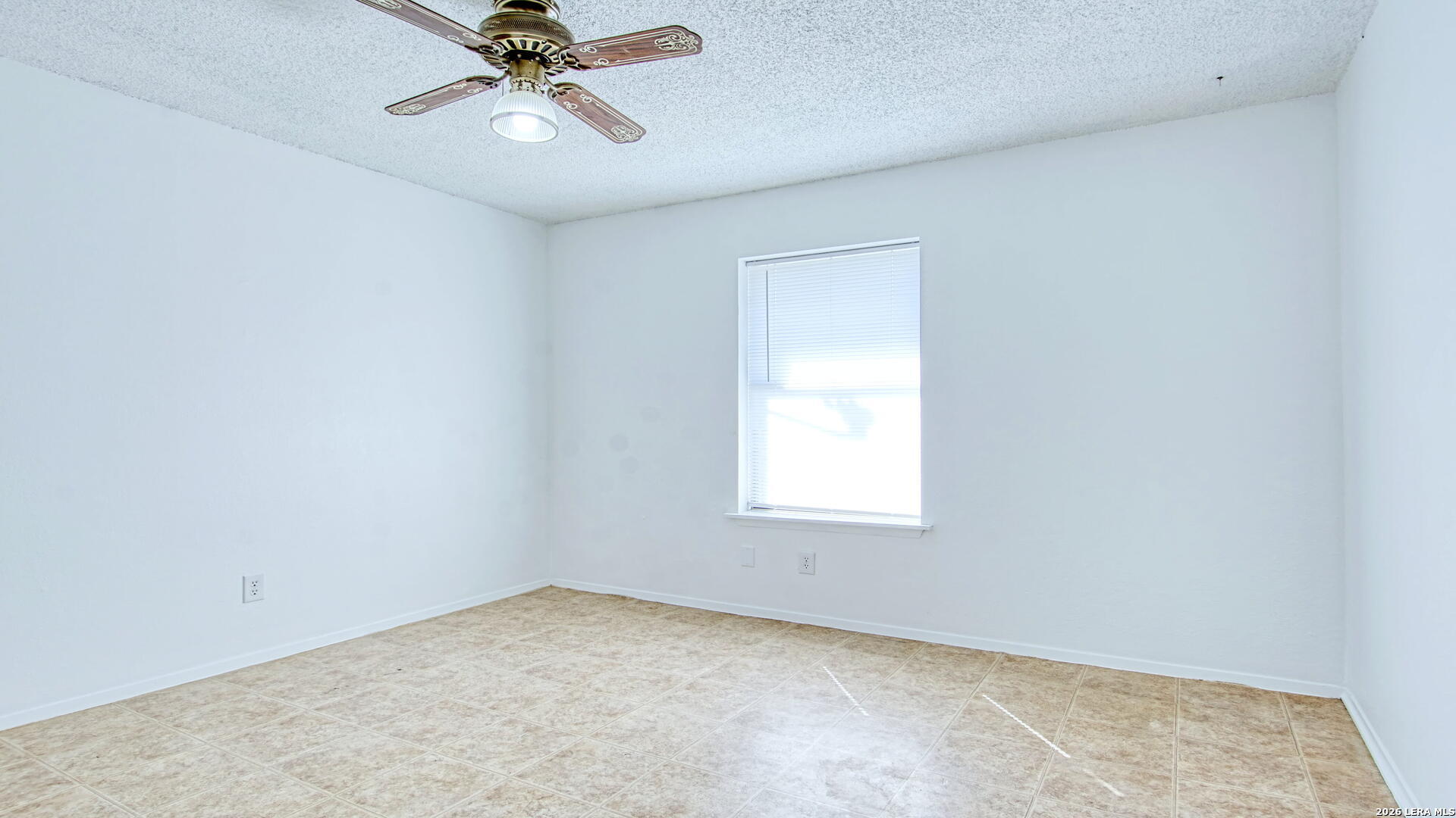 406 Pine Street Kenedy, TX 78119 - Photo 4 of 31 an empty room with a window and a fan
