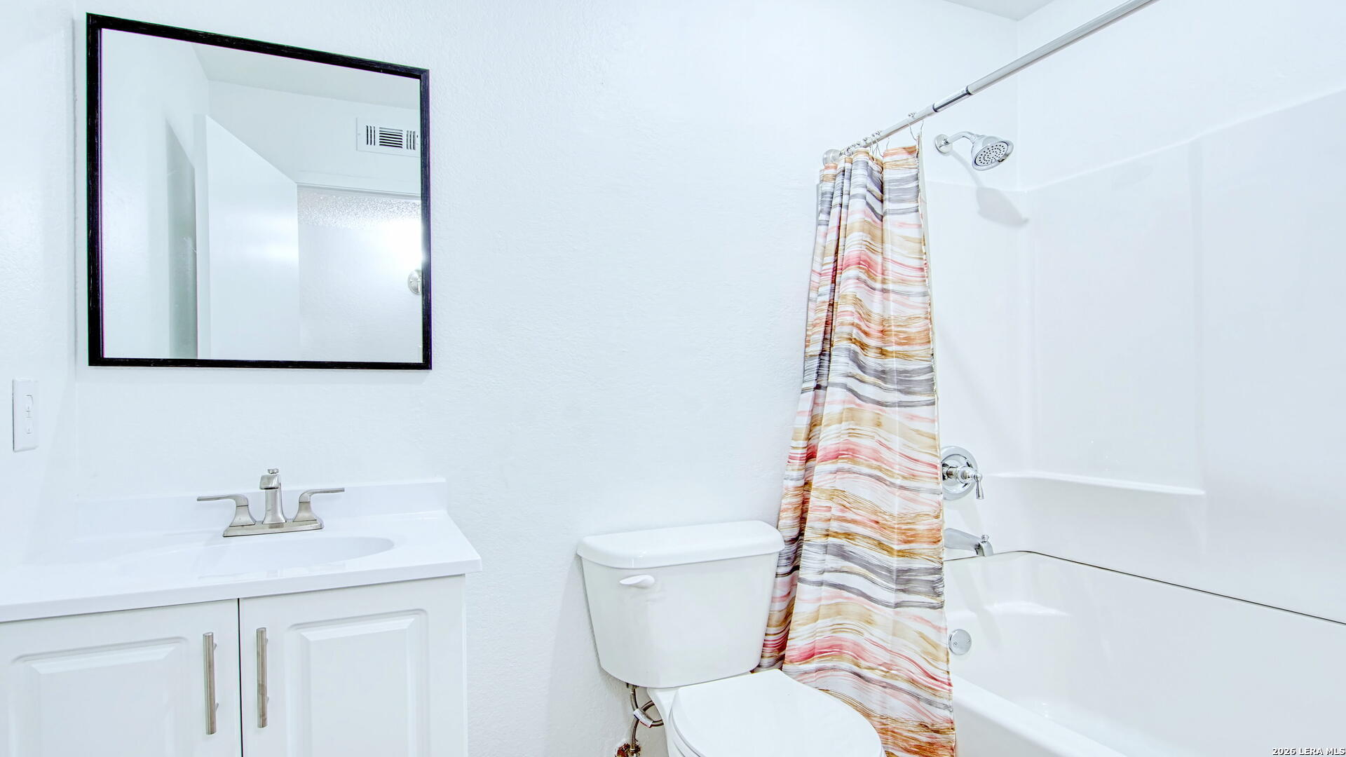 406 Pine Street Kenedy, TX 78119 - Photo 6 of 31 a bathroom with a sink a toilet and shower curtain