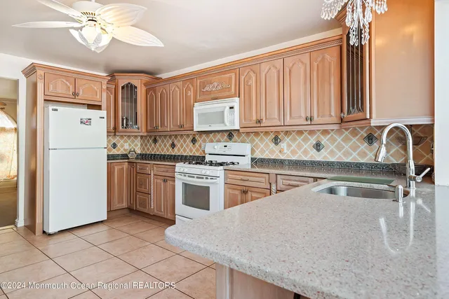 a kitchen with a refrigerator sink and white cabinets