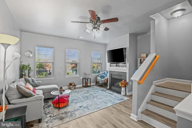 a living room with furniture a flat screen tv and a floor to ceiling window