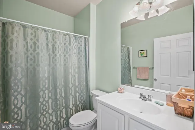 a bathroom with a sink a toilet and shower curtain