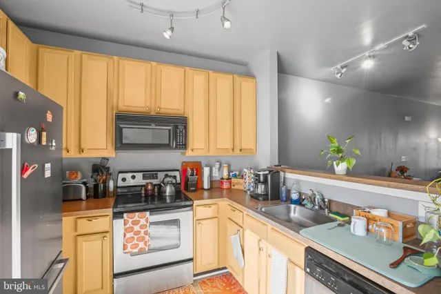 a kitchen with kitchen island granite countertop a sink appliances cabinets and a counter top space