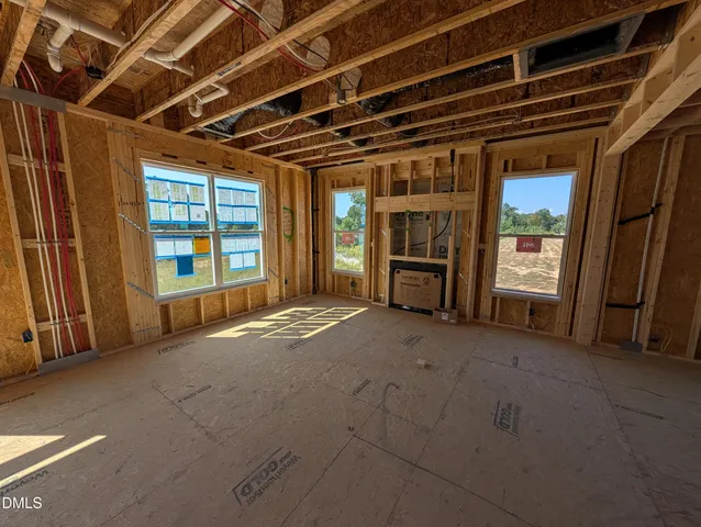 a view of an empty room with a fireplace and windows