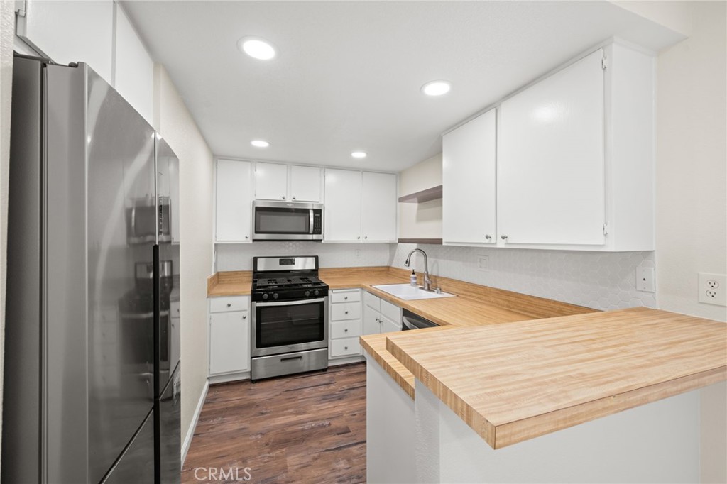 6911 Quail Place, Unit C Carlsbad, CA 92009 - Photo 5 of 18 a kitchen with a refrigerator a stove top oven and cabinets