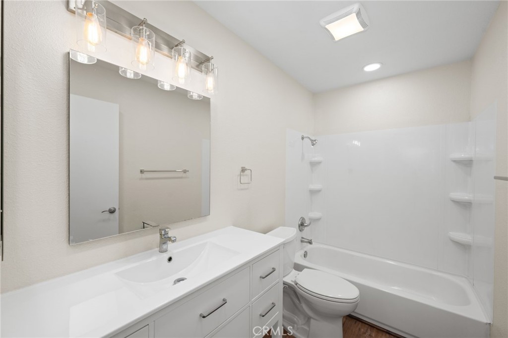 6911 Quail Place, Unit C Carlsbad, CA 92009 - Photo 9 of 18 a bathroom with a sink a toilet and a large mirror