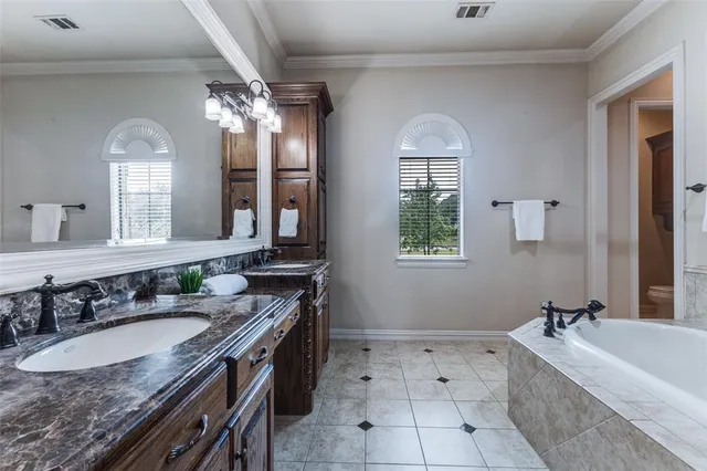a bathroom with a tub sink shower and mirror