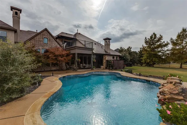 a front view of a house with swimming pool having outdoor seating