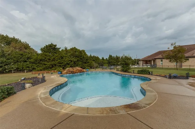an aerial view of a house with a yard and lake view