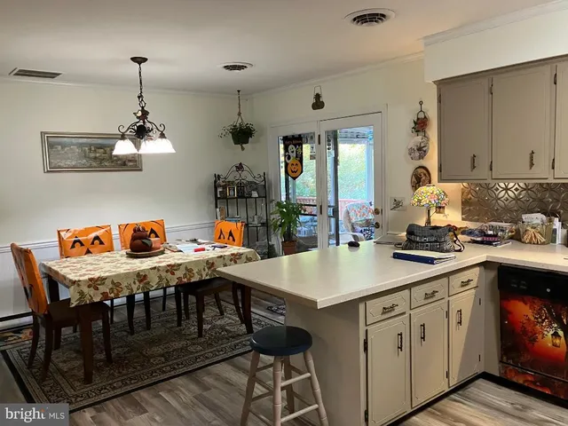 a kitchen with a table chairs and white cabinets