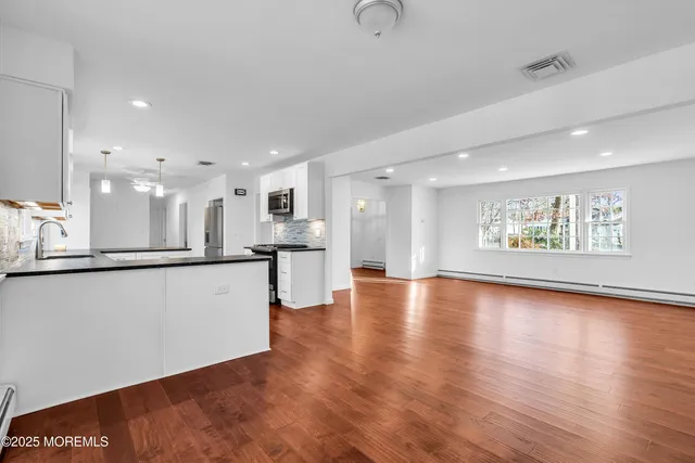 a kitchen with granite countertop a stove top oven a sink a counter space and cabinets